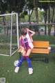 A woman sitting on a bench with a soccer ball.