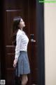 A woman standing in front of a wooden door.