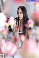 A woman sitting in front of a bunch of flowers.