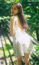 A woman in a floral dress standing on a wooden bridge.