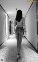 A woman walking down a long hallway in a hotel.