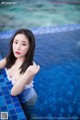 A woman in a white bathing suit sitting in a pool.