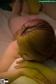 A woman laying on a bed with her head on her hands.