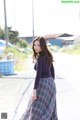 A woman in a long skirt is walking down the street.