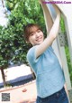 A woman leaning against a wall with her arms outstretched.