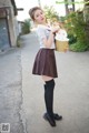 A woman in a school uniform holding a bucket of ice cream.