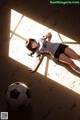 A girl laying on the ground next to a soccer ball.